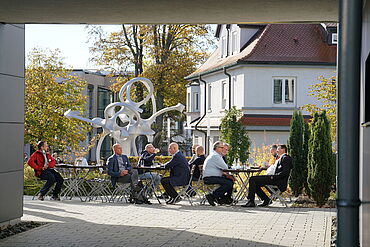 Visitantes tomando un café al sol